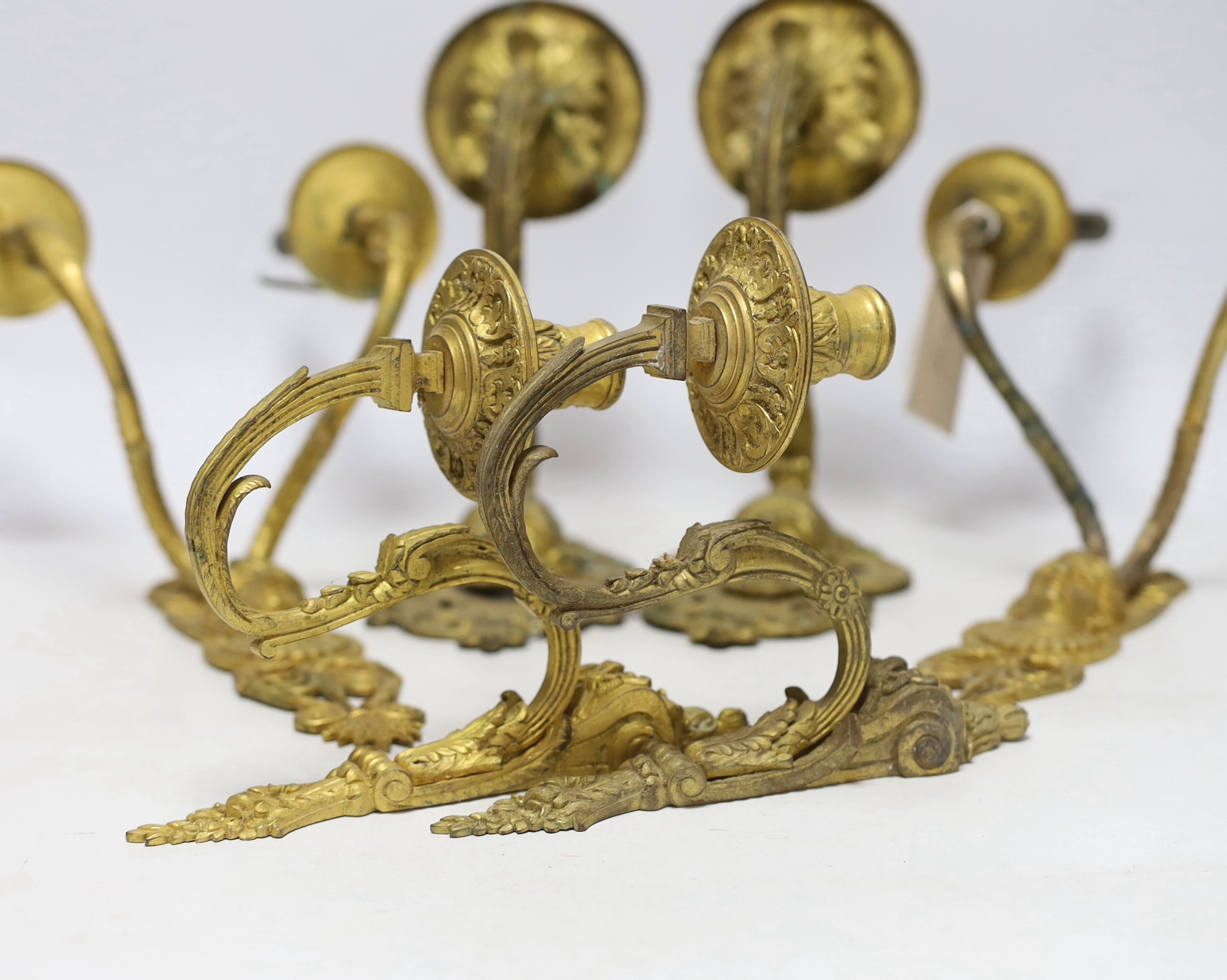 A pair of ormolu two branch wall lights, a pair of single branch mask wall lights and a small pair of wall lights, largest 32cm high